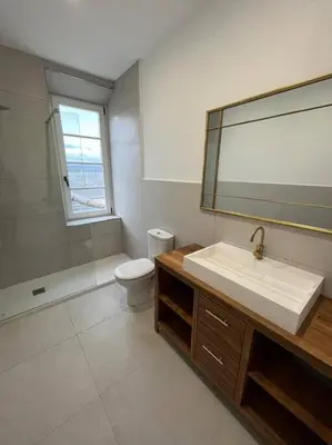 a bathroom with a sink and a toilet and a mirror at Apartamento en plaza de Ribadeo in Ribadeo