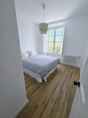 a white bedroom with a bed and a window at Apartamento en plaza de Ribadeo in Ribadeo