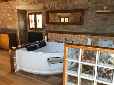 a large bath tub in a room with a sink at Villamia in Coirós