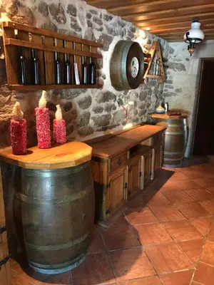a wine tasting room with a wooden table and wine barrels at Villamia in Coirós