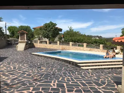 a swimming pool with two people sitting next to it at Villamia in Coirós