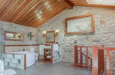 a stone bathroom with a tub and a sink at Villamia in Coirós
