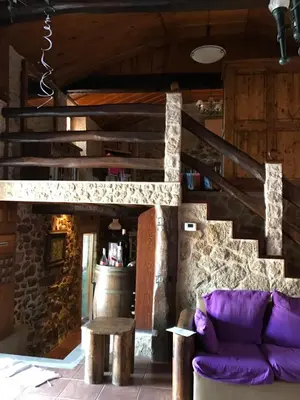 a living room with a purple couch and stairs at Villamia in Coirós