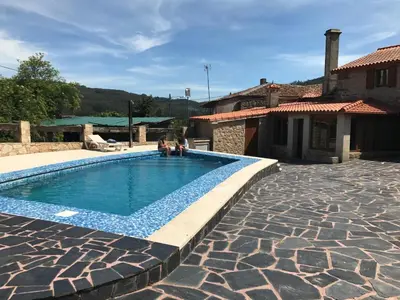 a swimming pool in a yard with a house at Villamia in Coirós