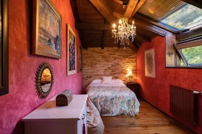 a bedroom with a bed in a room with red walls at Casa Muíñovedro in Chantada