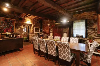 a dining room with a wooden table and chairs at Casa Muíñovedro in Chantada