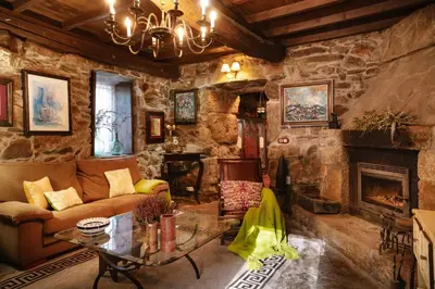 a living room with a couch and a fireplace at Casa Muíñovedro in Chantada