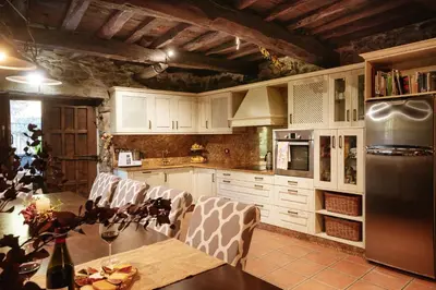 a kitchen with white cabinets and a table with chairs at Casa Muíñovedro in Chantada