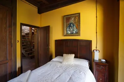 a bedroom with a bed and a painting on the wall at Casa Muíñovedro in Chantada