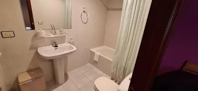 a white bathroom with a sink and a toilet at Pensión Río Cenza in Villarino de Conso