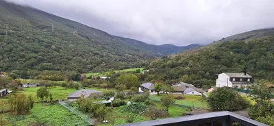 a small village in a valley with mountains at Pensión Río Cenza in Villarino de Conso