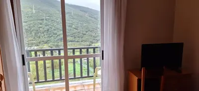 a large window with a view of a mountain at Pensión Río Cenza in Villarino de Conso