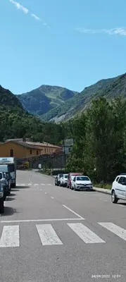 a parking lot with cars parked in front of a mountain at Ceraca in Pola de Somiedo