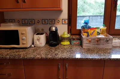 a kitchen counter with a microwave and some food on it at Chalet en Miño con vistas al mar in Miño