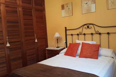 a bedroom with a bed with red pillows on it at Chalet en Miño con vistas al mar in Miño