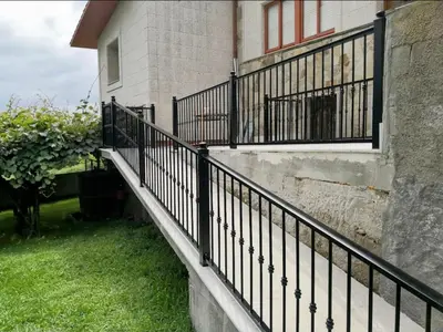 a black railing on the side of a house at Chalet en Miño con vistas al mar in Miño