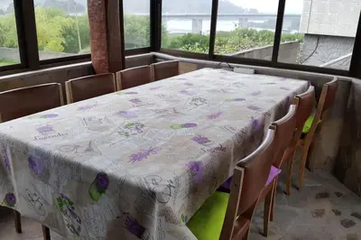 a table with a white table cloth with purple flowers on it at Chalet en Miño con vistas al mar in Miño