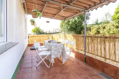 a table and chairs on a patio with a fence at Senel Home in Boimorto