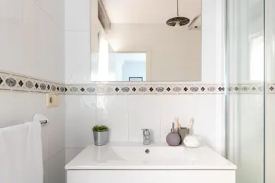 a white bathroom with a sink and a mirror at Senel Home in Boimorto