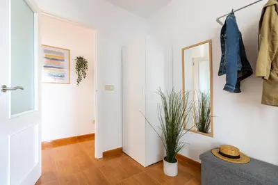 a white hallway with a mirror and a plant at Senel Home in Boimorto