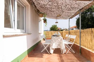 a patio with a table and chairs under an umbrella at Senel Home in Boimorto
