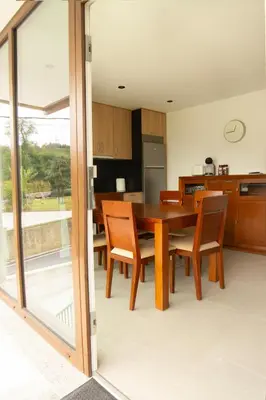 a kitchen and dining room with a wooden table and chairs at Apartamentos Camino Inglés II in Ordes