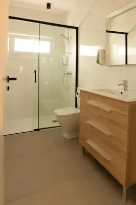 a bathroom with a toilet and a sink and a shower at Apartamentos Camino Inglés II in Ordes