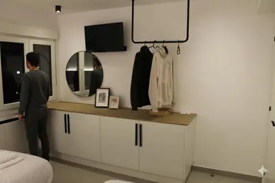 a man standing in a bedroom with a mirror at Apartamentos Camino Inglés II in Ordes