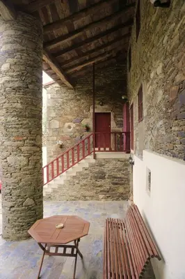 a room with a table and a bench in a building at A Pena de Augasantas in Oca de Abaixo