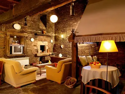 a living room with two chairs and a table at A Pena de Augasantas in Oca de Abaixo