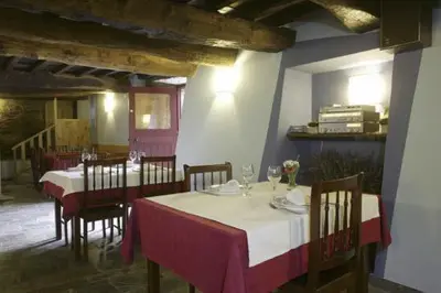 a dining room with tables and chairs in a building at A Pena de Augasantas in Oca de Abaixo
