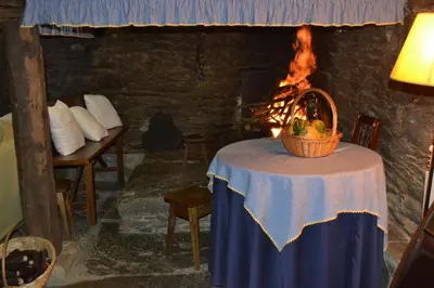 a table with a basket on it in a room with a fireplace at A Pena de Augasantas in Oca de Abaixo