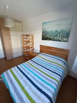 a bedroom with a bed with a colorful striped blanket at Mira a Parque in Lugo