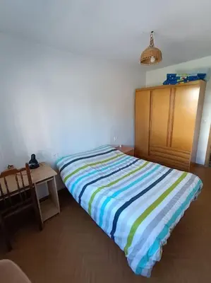 a bedroom with a striped bed and a table at Mira a Parque in Lugo