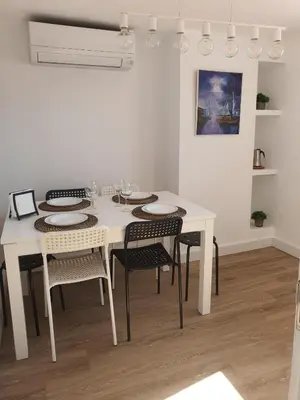a dining room with a white table and chairs at Apartamento casco viejo in Ourense