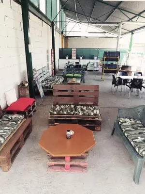 a room with several couches and a table and chairs at Hostal Monteclaro in Ponferrada