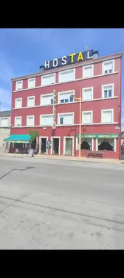 a red building with a sign on top of it at Hostal Monteclaro in Ponferrada