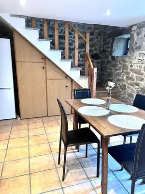 a dining room with a table and chairs and a staircase at Casa a Voada - Rural con Piscina Privada, Barbacoa y Juegos in Muiños