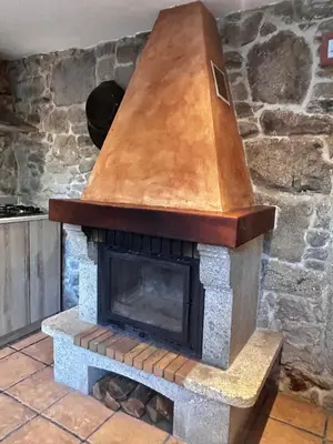 a stone fireplace with a wooden roof on top at Casa a Voada - Rural con Piscina Privada, Barbacoa y Juegos in Muiños
