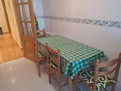 a table and chairs with a green and white checkered table cloth at EnFOZ PLAYA PISCINA Y PARKING in Foz