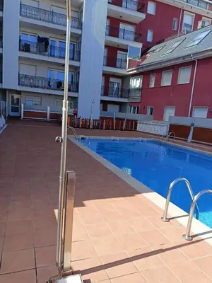 a swimming pool in front of a apartment building at EnFOZ PLAYA PISCINA Y PARKING in Foz