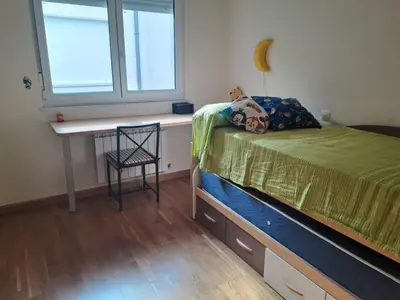 a bedroom with a bed and a desk and a window at EnFOZ PLAYA PISCINA Y PARKING in Foz