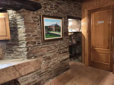 a hallway of a stone wall with a painting on it at Casa Moucheiro in Lugo