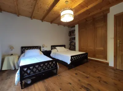 a bedroom with two beds and a chandelier at Casa Moucheiro in Lugo