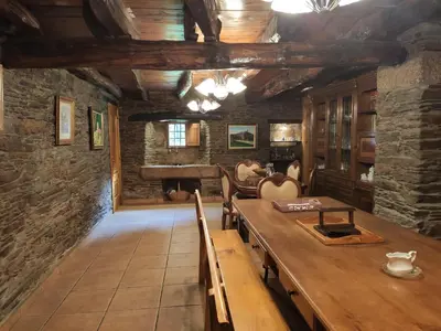a dining room with a table and a stone wall at Casa Moucheiro in Lugo