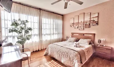 a bedroom with a bed and a large window at Apartamento con wifi en casco histórico Betanzos in Betanzos