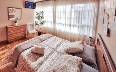 a bedroom with a bed and a dresser and a window at Apartamento con wifi en casco histórico Betanzos in Betanzos