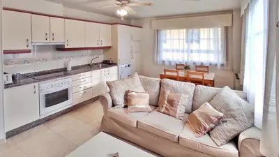 a living room with a couch and a kitchen at Apartamento con wifi en casco histórico Betanzos in Betanzos