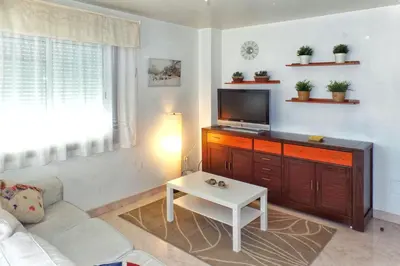 a living room with a tv and a white couch at Apartamento con wifi en casco histórico Betanzos in Betanzos