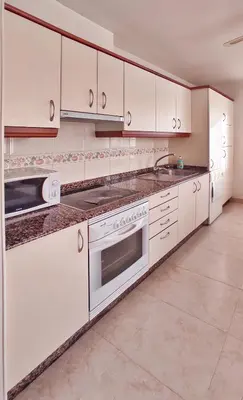 a kitchen with white cabinets and a sink at Apartamento con wifi en casco histórico Betanzos in Betanzos